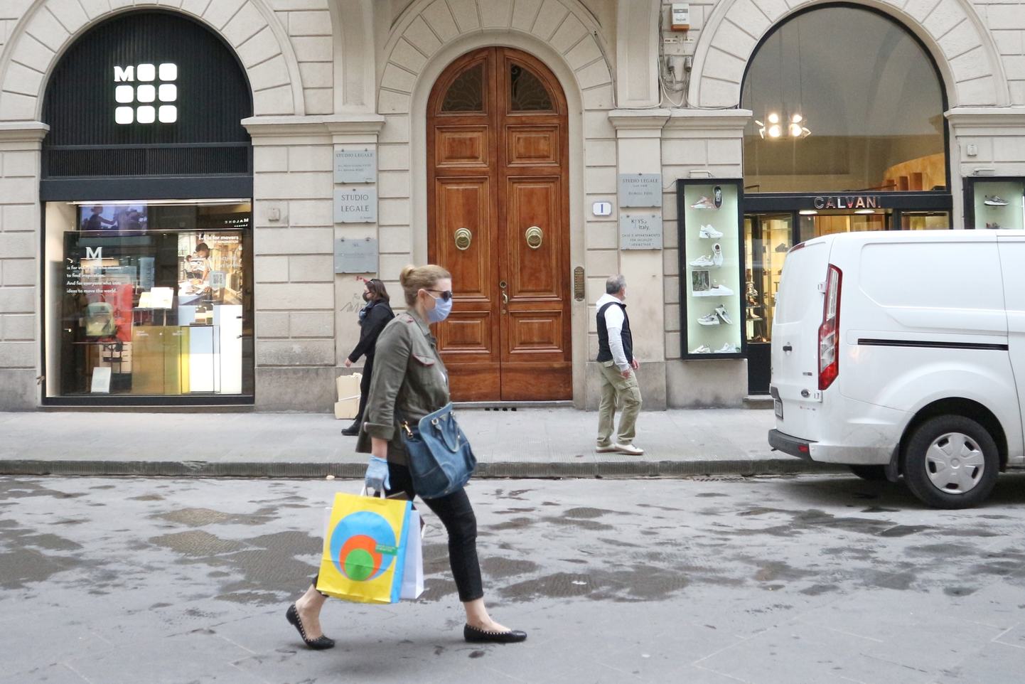 買い物袋をぶら下げ歩くイタリア人女性