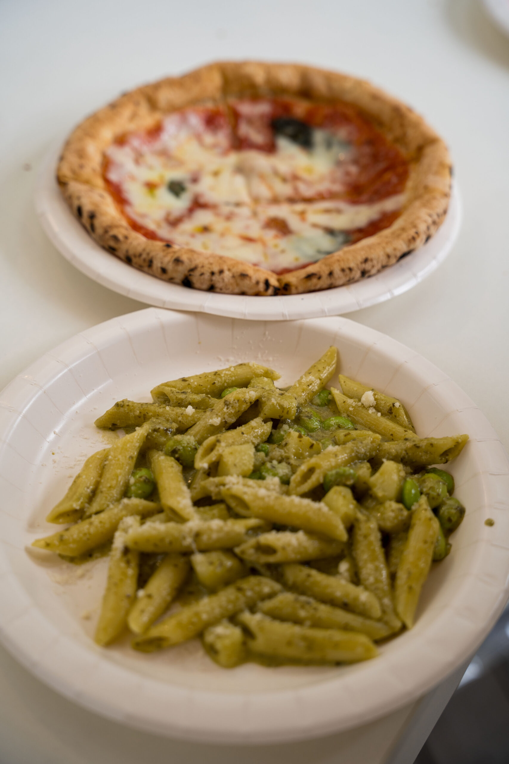 緑色のジェノベーゼパスタとピッツァマルゲリータ