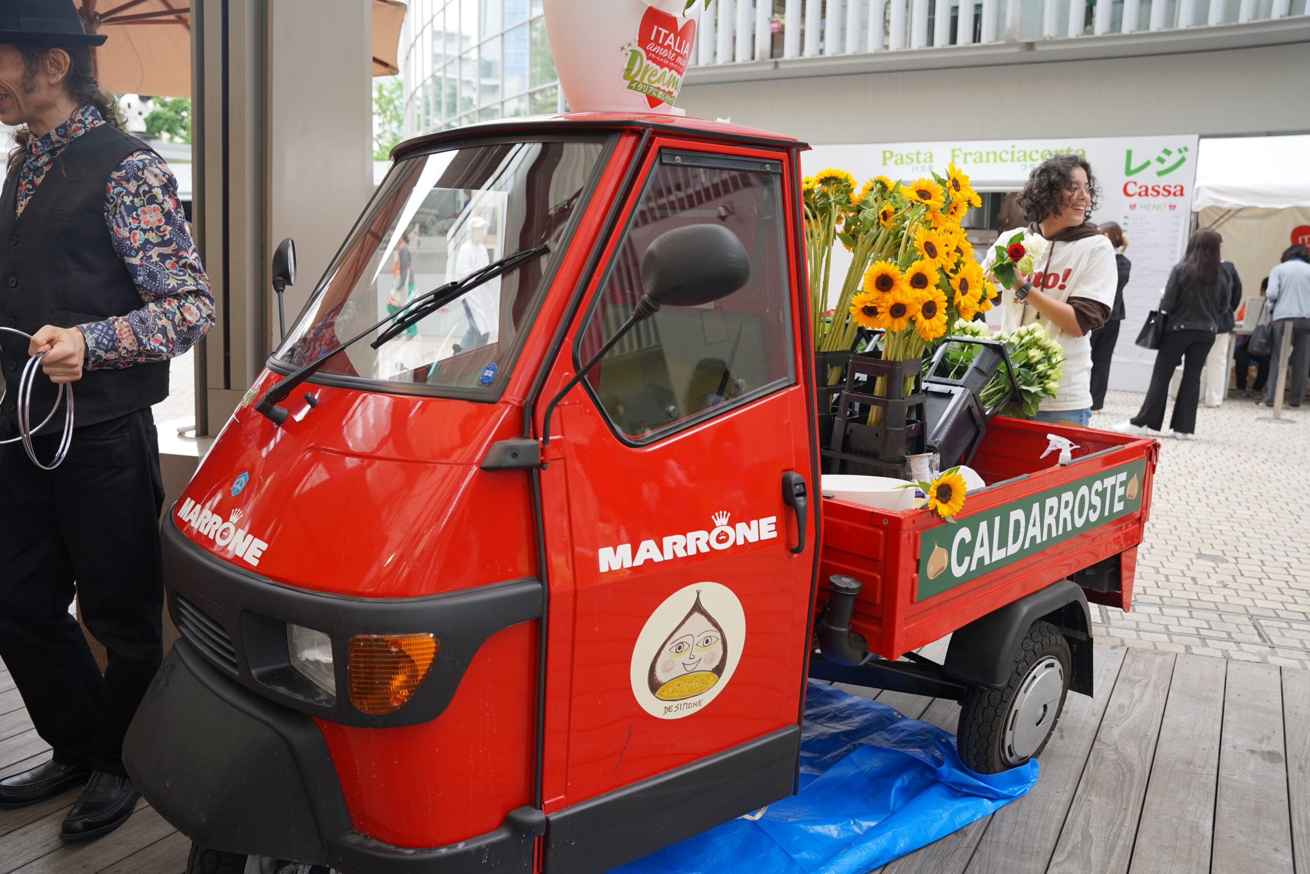 荷台にひまわりの花を積んだ小さな赤いトラック