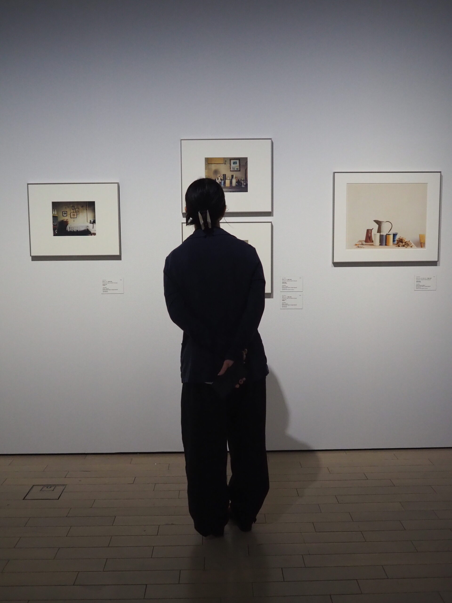 展覧会で作品を眺める女性の後ろ姿