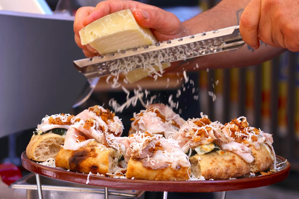 別の屋台では、ピッツァの上にゴータ・コッタをたっぷり。さらにペコリーノ・チーズをふりかけて