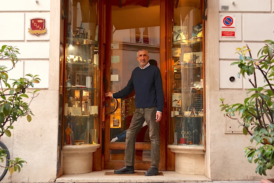 店主のアレッサンドロ‧ビッリさん。左の外壁に掲げられているのは、市から優れた歴史的店舗に与えられるプレート