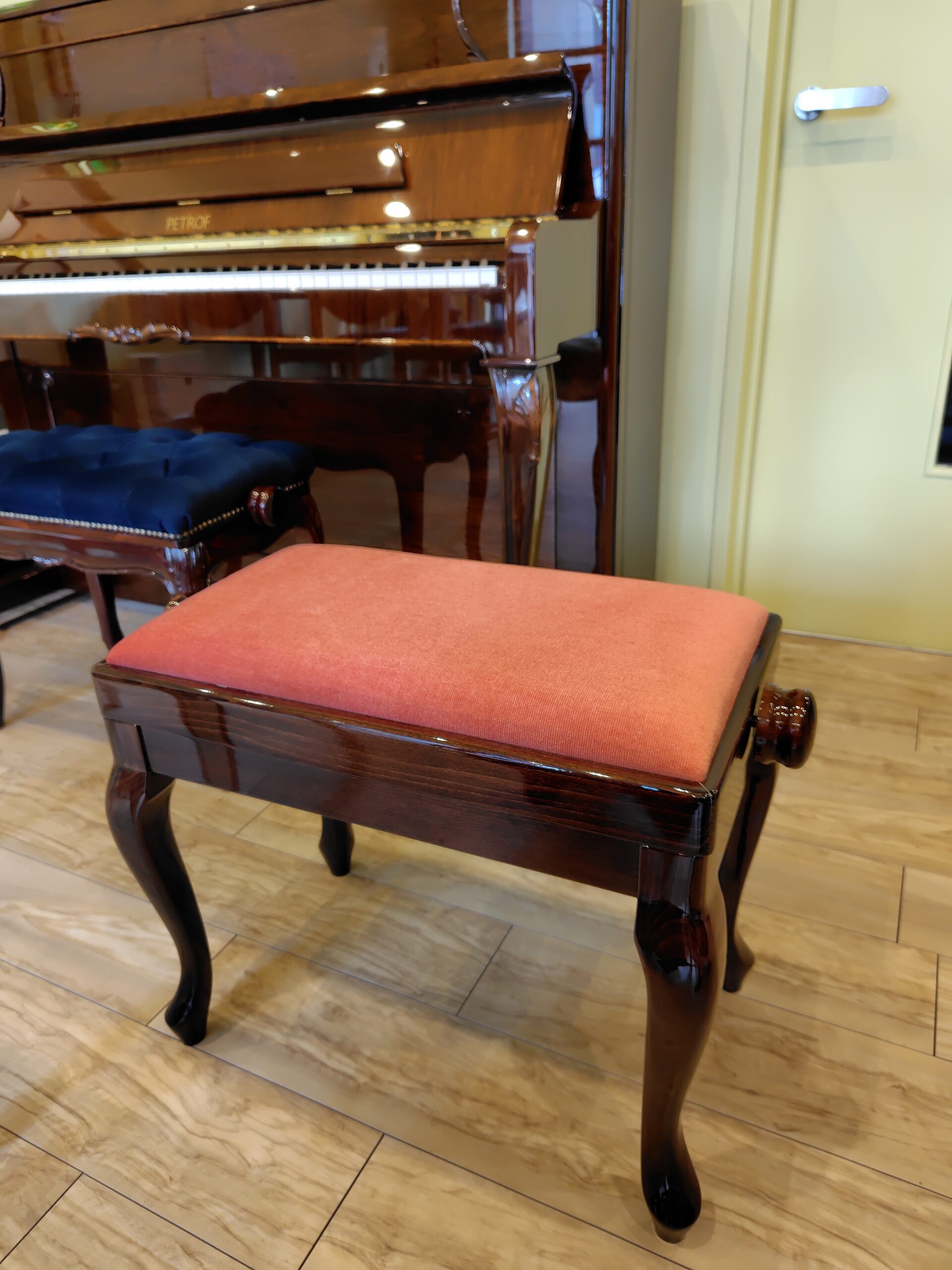 オレンジ色の張り地のピアノ椅子