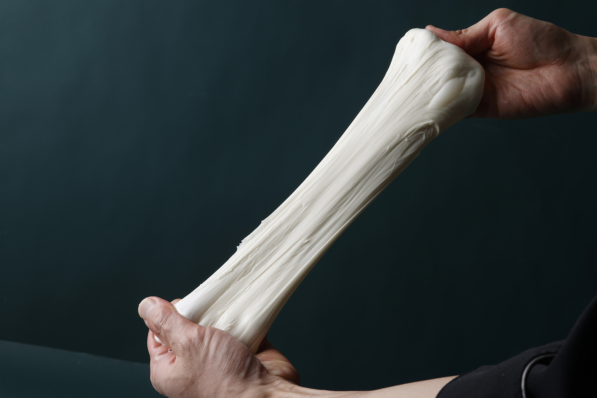 手で伸ばしているブッラータチーズ