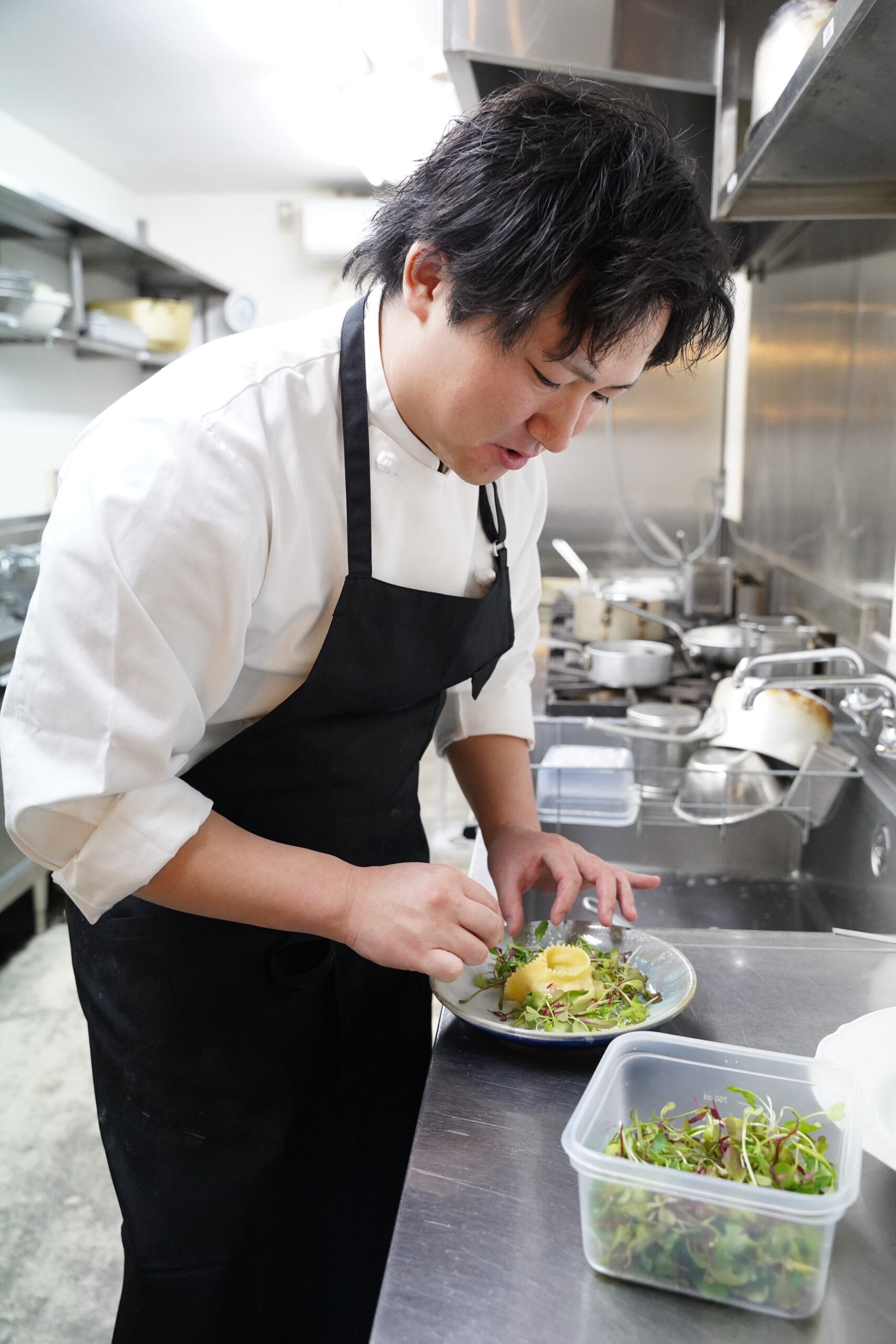 盛り付けをする菊池シェフ
