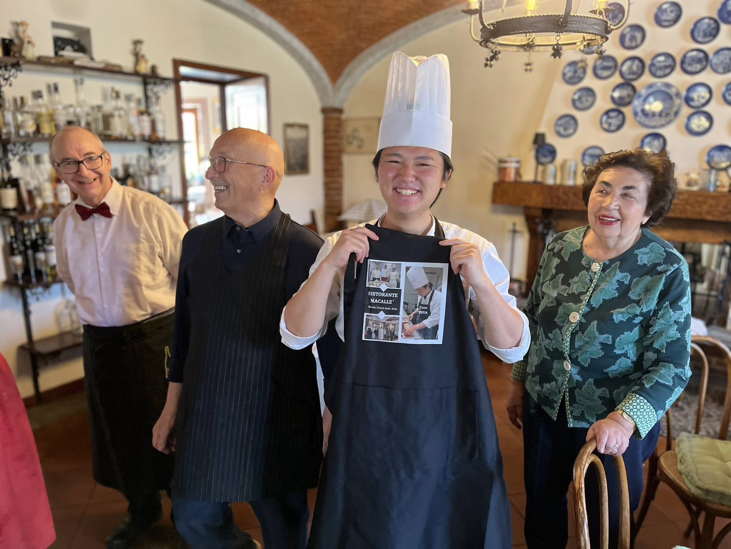 『マカッレ』のスタッフからエプロンを贈られて笑顔の菊池シェフ