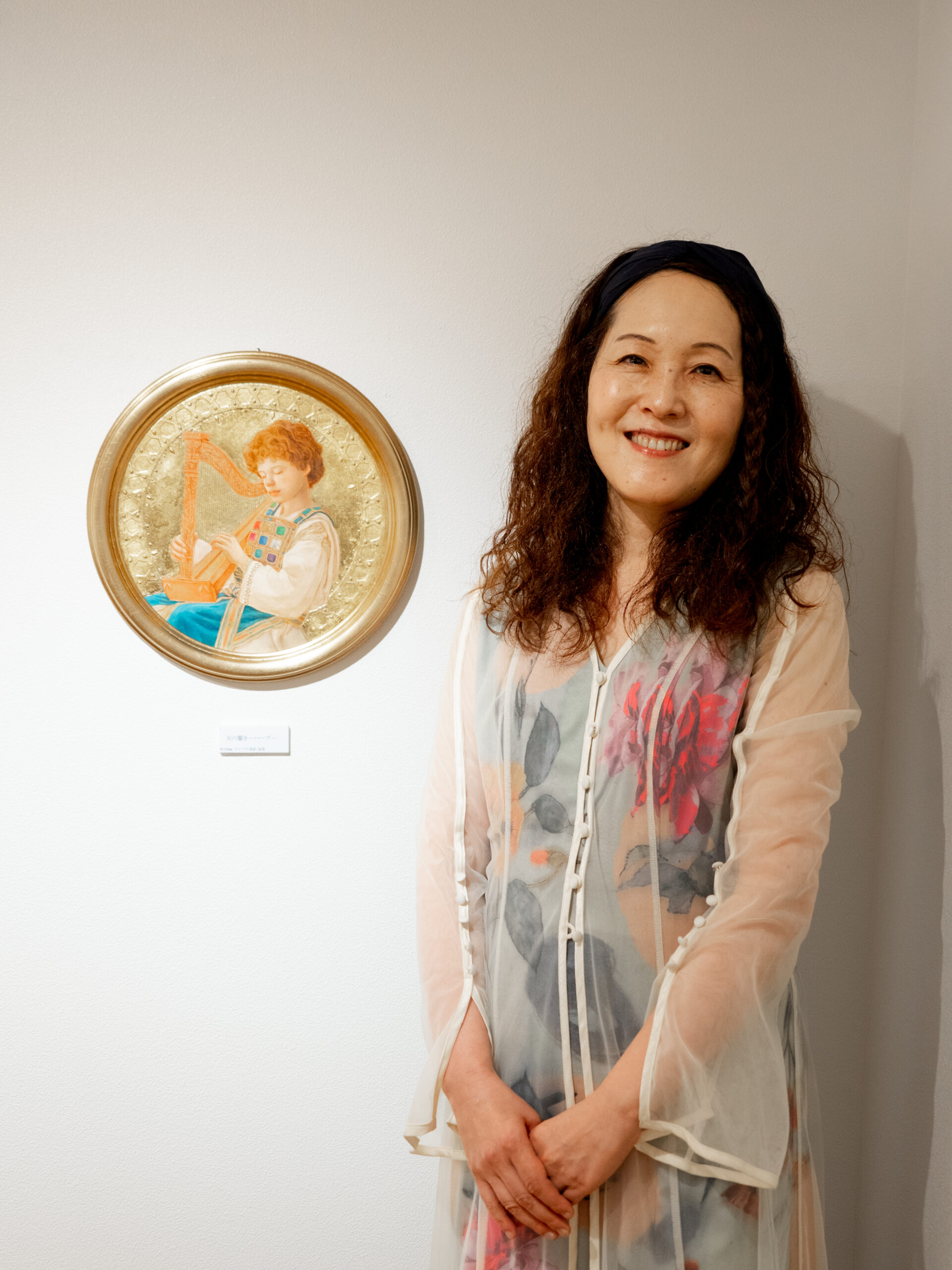 ハープを奏でる少年の絵画と画家の服部州恵さん