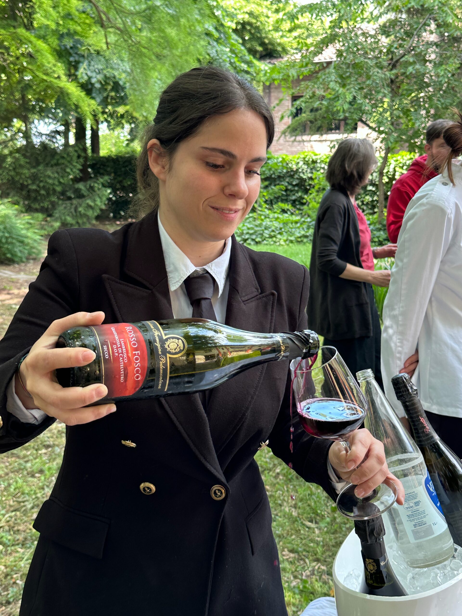 モデナ産のワインを注ぐ女性