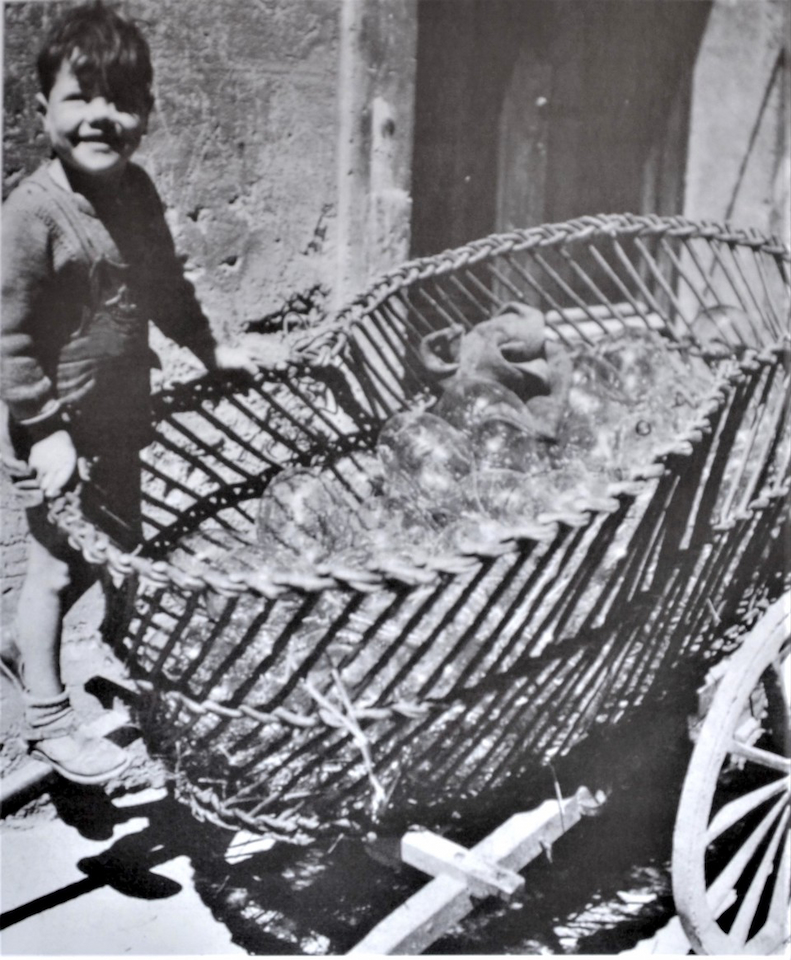 1950年代、手押し車に積まれた裸のガラス瓶。